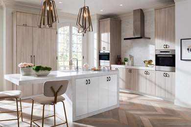 Idéer för ett mellanstort modernt kök, med en undermonterad diskho, släta luckor, skåp i ljust trä, marmorbänkskiva, vitt stänkskydd, stänkskydd i marmor, rostfria vitvaror, mellanmörkt trägolv, en köksö och brunt golv
