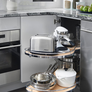 Kitchen - mid-sized contemporary u-shaped dark wood floor kitchen idea in Boston with an undermount sink, flat-panel cabinets, white cabinets, granite countertops, white backsplash, glass sheet backsplash and stainless steel appliances