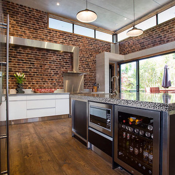 Under-bench drinks fridge and microwave in loft-style kitchen