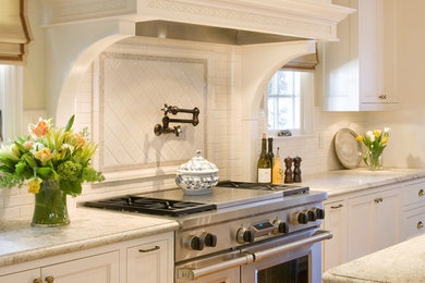 Example of a classic l-shaped eat-in kitchen design in San Francisco with recessed-panel cabinets, white cabinets, granite countertops, white backsplash, ceramic backsplash and stainless steel appliances