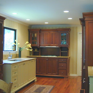 Inspiration for a timeless u-shaped eat-in kitchen remodel in New York with an undermount sink, shaker cabinets, medium tone wood cabinets, granite countertops and paneled appliances
