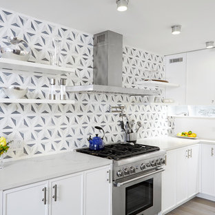 Small contemporary open concept kitchen remodeling - Open concept kitchen - small contemporary l-shaped light wood floor open concept kitchen idea in New York with white cabinets, quartz countertops, multicolored backsplash, stainless steel appliances, an island, an undermount sink, recessed-panel cabinets and marble backsplash