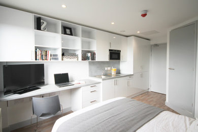 Small contemporary single-wall enclosed kitchen in Other with white cabinets, laminate countertops and laminate floors.