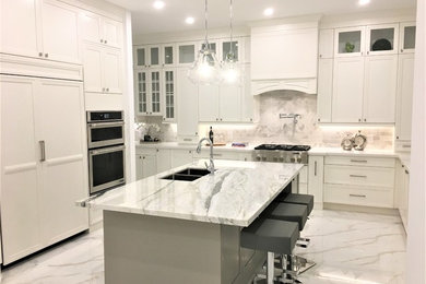 Foto på ett stort vintage vit kök, med en undermonterad diskho, luckor med infälld panel, vita skåp, bänkskiva i kvarts, vitt stänkskydd, stänkskydd i marmor, integrerade vitvaror, klinkergolv i porslin, en köksö och vitt golv