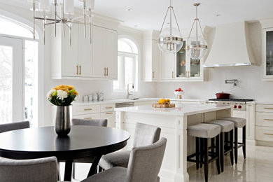 Eat-in kitchen - transitional l-shaped beige floor eat-in kitchen idea in Toronto with an undermount sink, recessed-panel cabinets, white cabinets, white backsplash, an island and white countertops