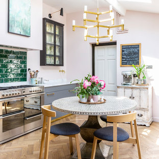 Inspiration for a romantic single-wall kitchen/diner in Gloucestershire with flat-panel cabinets, grey cabinets, marble worktops, green splashback, metro tiled splashback, stainless steel appliances, light hardwood flooring, no island, beige floors and white worktops.