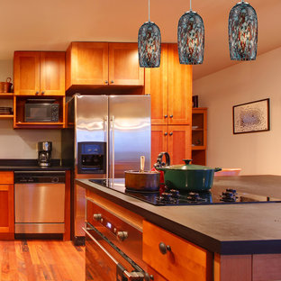 Large tropical l-shaped eat-in kitchen in New York with a drop-in sink, raised-panel cabinets, light wood cabinets, limestone benchtops, white splashback, ceramic splashback, stainless steel appliances, medium hardwood floors and with island.