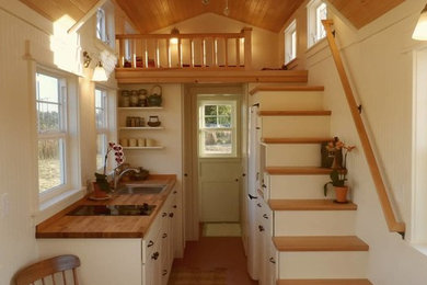 ポートランドにある小さなラスティックスタイルのおしゃれなキッチン (シングルシンク、フラットパネル扉のキャビネット、白いキャビネット、木材カウンター、白い調理設備、アイランドなし) の写真