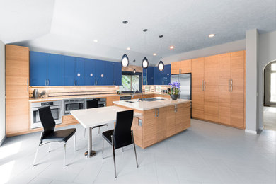 Inspiration for a large contemporary white floor kitchen remodel in Houston with an undermount sink, flat-panel cabinets, blue cabinets, beige backsplash, stainless steel appliances and two islands