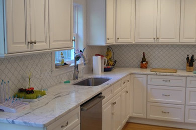 Foto di una cucina chic di medie dimensioni con lavello sottopiano, ante con riquadro incassato, ante bianche, top in marmo, paraspruzzi bianco, elettrodomestici in acciaio inossidabile e parquet chiaro