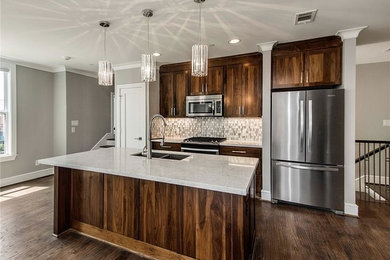 Example of a small minimalist single-wall dark wood floor open concept kitchen design in Dallas with an undermount sink, shaker cabinets, dark wood cabinets, quartz countertops, white backsplash, glass tile backsplash, stainless steel appliances and an island