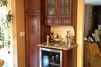 Foto de cocina clásica con puertas de armario de madera en tonos medios, encimera de granito, salpicadero beige, salpicadero de azulejos de piedra, suelo de baldosas de cerámica y una isla