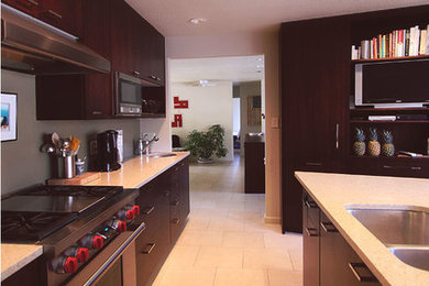 Immagine di una cucina moderna di medie dimensioni con lavello a doppia vasca, ante lisce, ante in legno bruno, top in quarzo composito, paraspruzzi grigio, elettrodomestici in acciaio inossidabile e pavimento in travertino