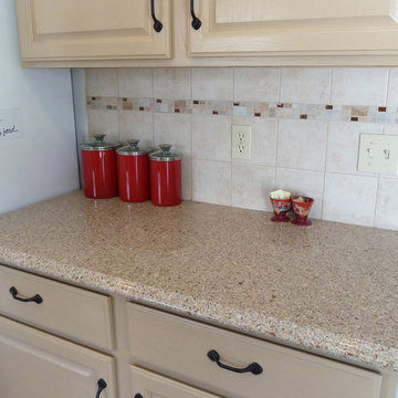 Updated quartz countertop and tile backsplash with red canisters