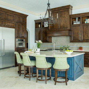 Ejemplo de cocina comedor en L, clásica, pequeña, con fregadero sobremueble, armarios con paneles con relieve, puertas de armario de madera en tonos medios, encimera de cuarcita, salpicadero beige, electrodomésticos de acero inoxidable, suelo de baldosas de porcelana, una isla, suelo beige, encimeras beige y salpicadero de piedra caliza