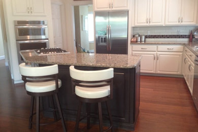 Kitchen photo in Portland with raised-panel cabinets and an island