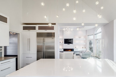 Example of a large trendy u-shaped dark wood floor and gray floor eat-in kitchen design in Bridgeport with an undermount sink, flat-panel cabinets, white cabinets, quartz countertops, metallic backsplash, glass tile backsplash, stainless steel appliances, an island and white countertops