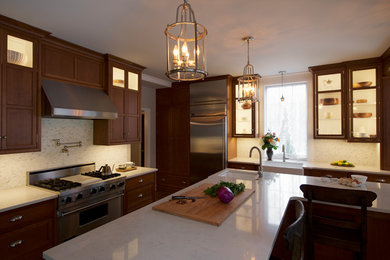 Exempel på ett stort klassiskt kök, med en undermonterad diskho, släta luckor, skåp i mellenmörkt trä, bänkskiva i kvarts, vitt stänkskydd, stänkskydd i mosaik, rostfria vitvaror, mellanmörkt trägolv och en köksö