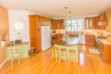 Eat-in kitchen - mid-sized traditional u-shaped medium tone wood floor and brown floor eat-in kitchen idea in DC Metro with a double-bowl sink, flat-panel cabinets, medium tone wood cabinets, quartzite countertops, white backsplash, subway tile backsplash, white appliances, an island and beige countertops