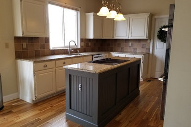 Example of a mid-sized classic l-shaped eat-in kitchen design in St Louis with raised-panel cabinets, white cabinets and an island