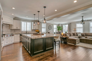 Example of a large transitional l-shaped medium tone wood floor kitchen design in Los Angeles with a single-bowl sink, white cabinets, quartz countertops, gray backsplash, stone tile backsplash, stainless steel appliances and an island
