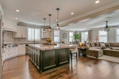 Large classic l-shaped kitchen in Los Angeles with a single-bowl sink, white cabinets, engineered stone countertops, grey splashback, stone tiled splashback, stainless steel appliances, medium hardwood flooring and an island.