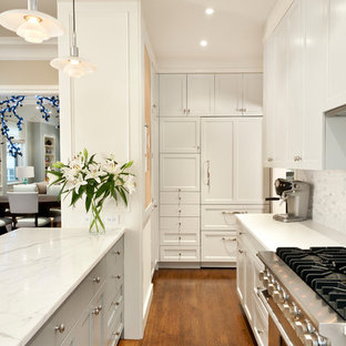 Ejemplo de cocina en U, tradicional renovada, pequeña, abierta, con salpicadero verde, electrodomésticos con paneles, fregadero bajoencimera, encimera de mármol, salpicadero de azulejos de piedra, suelo de madera en tonos medios, península, armarios estilo shaker, puertas de armario blancas y suelo marrón