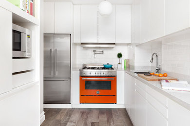 Inspiration for a small contemporary l-shaped porcelain tile and gray floor enclosed kitchen remodel in New York with an undermount sink, flat-panel cabinets, white cabinets, subway tile backsplash, colored appliances, no island, white backsplash and white countertops
