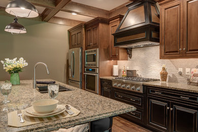 Eat-in kitchen - mid-sized traditional galley medium tone wood floor eat-in kitchen idea in Other with a drop-in sink, beaded inset cabinets, dark wood cabinets, granite countertops, beige backsplash, stone slab backsplash, stainless steel appliances and an island