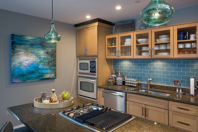 Eat-in kitchen - mid-sized transitional u-shaped eat-in kitchen idea in Columbus with a double-bowl sink, glass-front cabinets, light wood cabinets, granite countertops, blue backsplash, subway tile backsplash, stainless steel appliances and an island