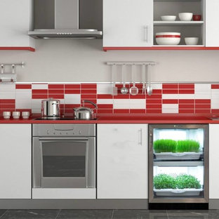 Design ideas for a mid-sized contemporary single-wall separate kitchen in New York with a drop-in sink, flat-panel cabinets, white cabinets, solid surface benchtops, multi-coloured splashback, mosaic tile splashback, stainless steel appliances, porcelain floors, no island, grey floor and red benchtop.