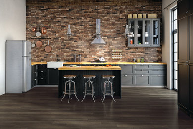 Eat-in kitchen - large industrial single-wall porcelain tile eat-in kitchen idea in Boise with ceramic backsplash, an island, a farmhouse sink, recessed-panel cabinets, black cabinets and wood countertops
