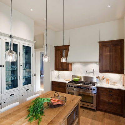 Inspiration for a timeless enclosed kitchen remodel in Austin with stainless steel appliances, wood countertops, dark wood cabinets, white backsplash and stone slab backsplash