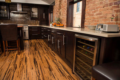 Large l-shaped medium tone wood floor eat-in kitchen photo in Austin with a double-bowl sink, dark wood cabinets, brown backsplash, stainless steel appliances and an island