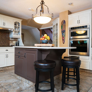 Inspiration for a mid-sized traditional u-shaped eat-in kitchen in Calgary with raised-panel cabinets, white cabinets, quartz benchtops, with island, multi-coloured floor, white benchtop, beige splashback, slate splashback, stainless steel appliances and porcelain floors.