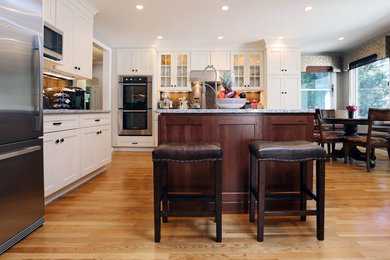 Example of a mid-sized farmhouse l-shaped light wood floor and beige floor eat-in kitchen design in Boston with an undermount sink, shaker cabinets, white cabinets, granite countertops, brown backsplash, porcelain backsplash, stainless steel appliances and an island