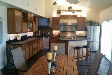 Maritime Wohnküche in L-Form mit hellbraunen Holzschränken, Küchengeräten aus Edelstahl und Kücheninsel in Miami