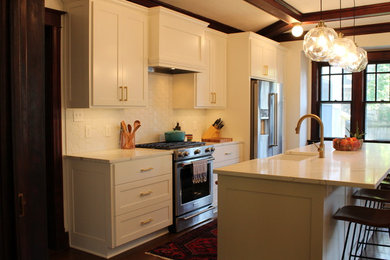 Inspiration for a mid-sized contemporary galley dark wood floor and brown floor open concept kitchen remodel in Kansas City with a farmhouse sink, shaker cabinets, stainless steel cabinets, quartz countertops, white backsplash, ceramic backsplash, stainless steel appliances, an island and white countertops