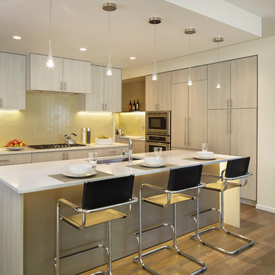 Example of a trendy kitchen design in Denver with an undermount sink, flat-panel cabinets, white cabinets, yellow backsplash and stainless steel appliances