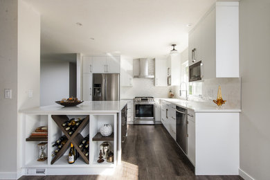 Inspiration for a mid-sized contemporary l-shaped medium tone wood floor eat-in kitchen remodel in Vancouver with an undermount sink, flat-panel cabinets, white cabinets, quartz countertops, white backsplash, ceramic backsplash, stainless steel appliances and an island