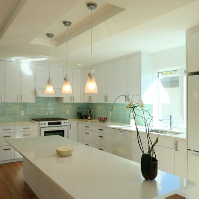 Minimalist l-shaped kitchen photo in Vancouver with white appliances, a single-bowl sink, white cabinets, blue backsplash and subway tile backsplash