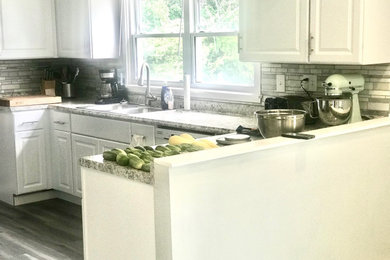 Inspiration for a large modern u-shaped laminate floor, gray floor and vaulted ceiling eat-in kitchen remodel in Cincinnati with a double-bowl sink, shaker cabinets, white cabinets, laminate countertops, white backsplash, mosaic tile backsplash, stainless steel appliances and no island