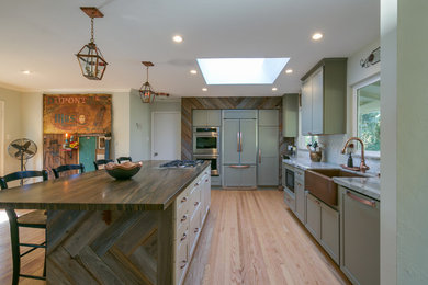 Inspiration for a large transitional l-shaped light wood floor open concept kitchen remodel in San Francisco with a farmhouse sink, shaker cabinets, gray cabinets, marble countertops, multicolored backsplash, mosaic tile backsplash, paneled appliances and an island