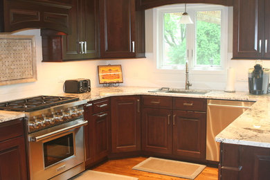シカゴにあるトランジショナルスタイルのおしゃれなキッチン (シングルシンク、レイズドパネル扉のキャビネット、濃色木目調キャビネット、御影石カウンター、白いキッチンパネル、サブウェイタイルのキッチンパネル、シルバーの調理設備、無垢フローリング) の写真