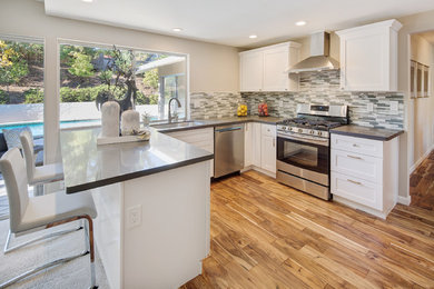 Example of a mid-sized transitional u-shaped medium tone wood floor and brown floor eat-in kitchen design in San Francisco with a single-bowl sink, shaker cabinets, white cabinets, quartz countertops, multicolored backsplash, matchstick tile backsplash, stainless steel appliances, a peninsula and gray countertops