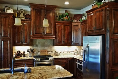 Inspiration for a transitional l-shaped eat-in kitchen remodel in Dallas with granite countertops, an undermount sink, dark wood cabinets, beige backsplash, cement tile backsplash, stainless steel appliances and an island