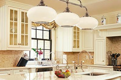 Eat-in kitchen - mid-sized traditional u-shaped eat-in kitchen idea in Salt Lake City with a drop-in sink, raised-panel cabinets, white cabinets, quartz countertops, beige backsplash, stone tile backsplash, stainless steel appliances and an island