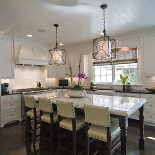 Example of a trendy l-shaped kitchen design in Charlotte with a farmhouse sink, recessed-panel cabinets, white cabinets, white backsplash, subway tile backsplash and paneled appliances