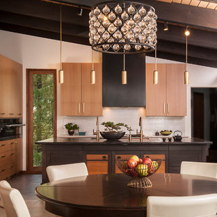 Inspiration for a large tropical single-wall eat-in kitchen in Seattle with an undermount sink, flat-panel cabinets, light wood cabinets, wood benchtops, grey splashback, porcelain floors, with island, grey floor and black benchtop.