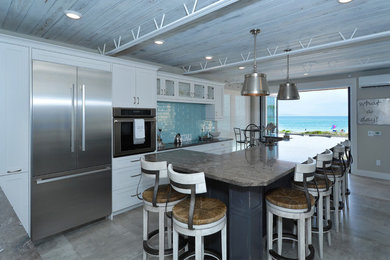 Large beach style l-shaped gray floor and porcelain tile open concept kitchen photo in Other with a drop-in sink, granite countertops, stainless steel appliances, shaker cabinets, white cabinets, blue backsplash, glass tile backsplash and an island